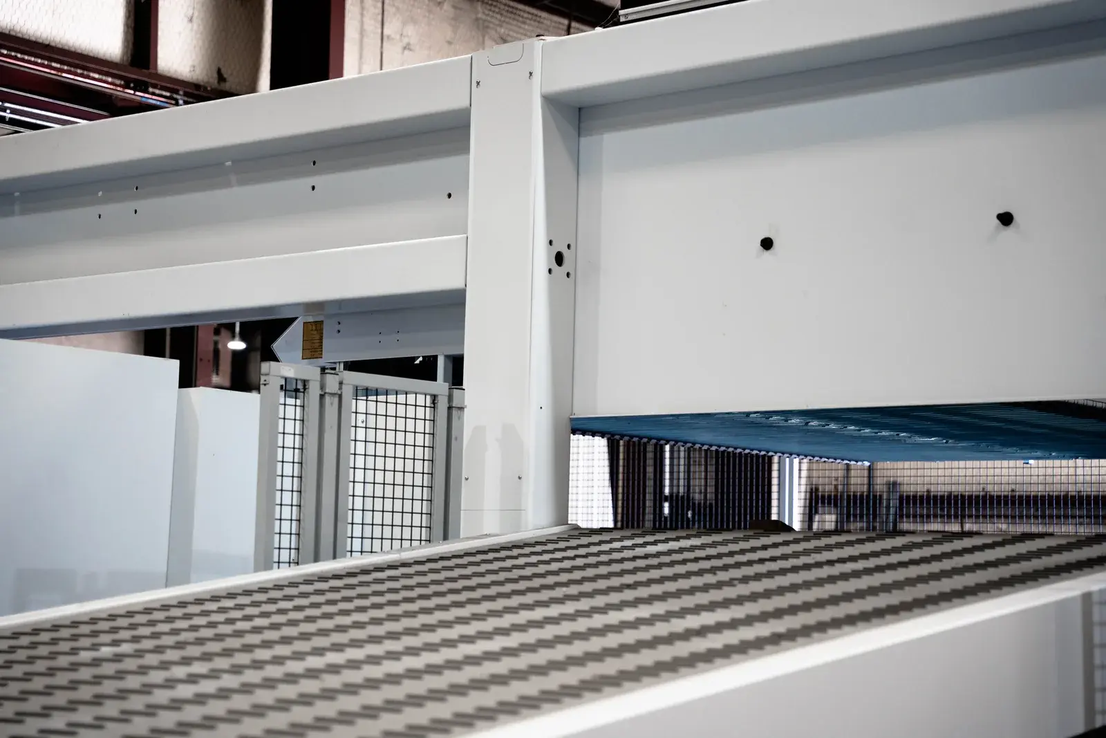 Sheet-handling table and white machine structure in the fabrication shop.